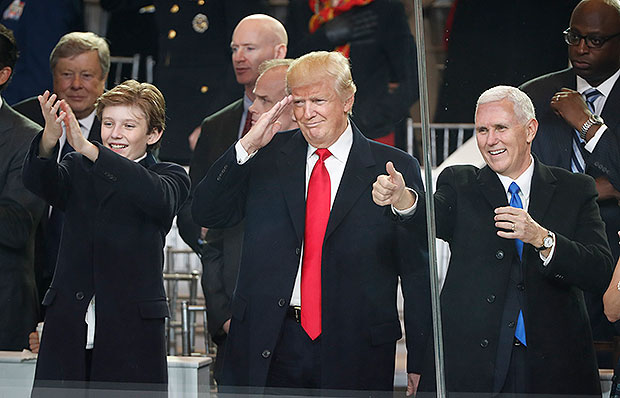 Barron Trump, his father President Donald Trump, and Vice President Mike Pence cheering the Presidential Inauguration parade in Washington on Jan. 20, 2017