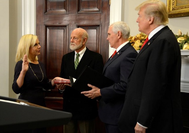 Nielsen's dad James holding up the Bible at her swearing-in ceremony